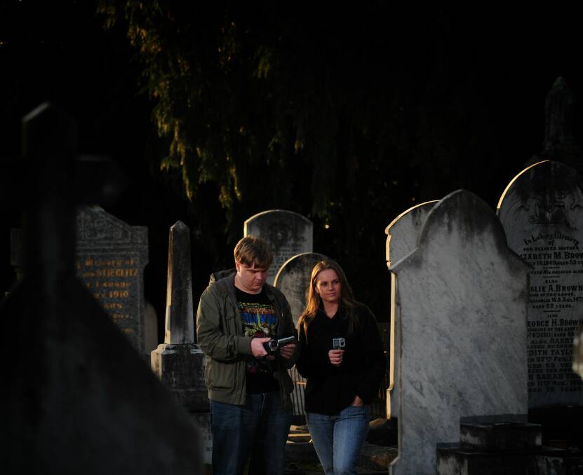 LEFT: Launceston Paranormal Society co-founders Brendan Crates and Conor Kaukenas using equipment to track possible ghost activity at Carr Villa cemetery. 