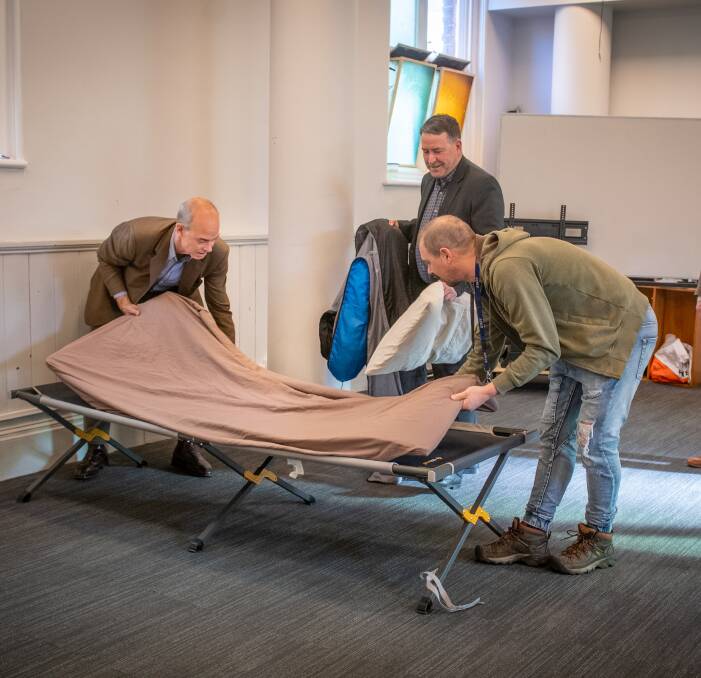 HELPING HAND: Minister for Housing, Guy Barnett with City Mission's Supervisor of Safe Space Jade Van Stralen as they make one of the beds for the homeless, with City Mission CEO Stephen Brown. Picture: Paul Scambler 