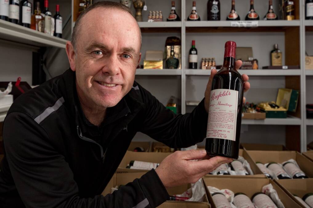 GRAPE EXPECTATIONS: Armitage Auctions auctioneer Neil O'Brien with a 1959 Penfolds Grange Hermitage. Picture: Phillip Biggs