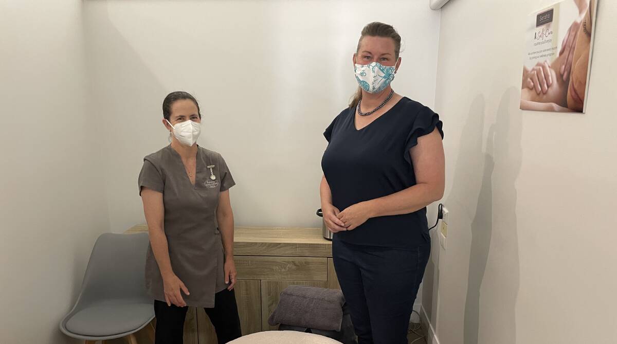 Owner of Sarah's Family Wellness Centre, Sarah Jordan-Ross, inside one of her company's massage therapy rooms with Labor's Shadow Minister for Small Business, Janie Finlay. Picture: Luke Miller