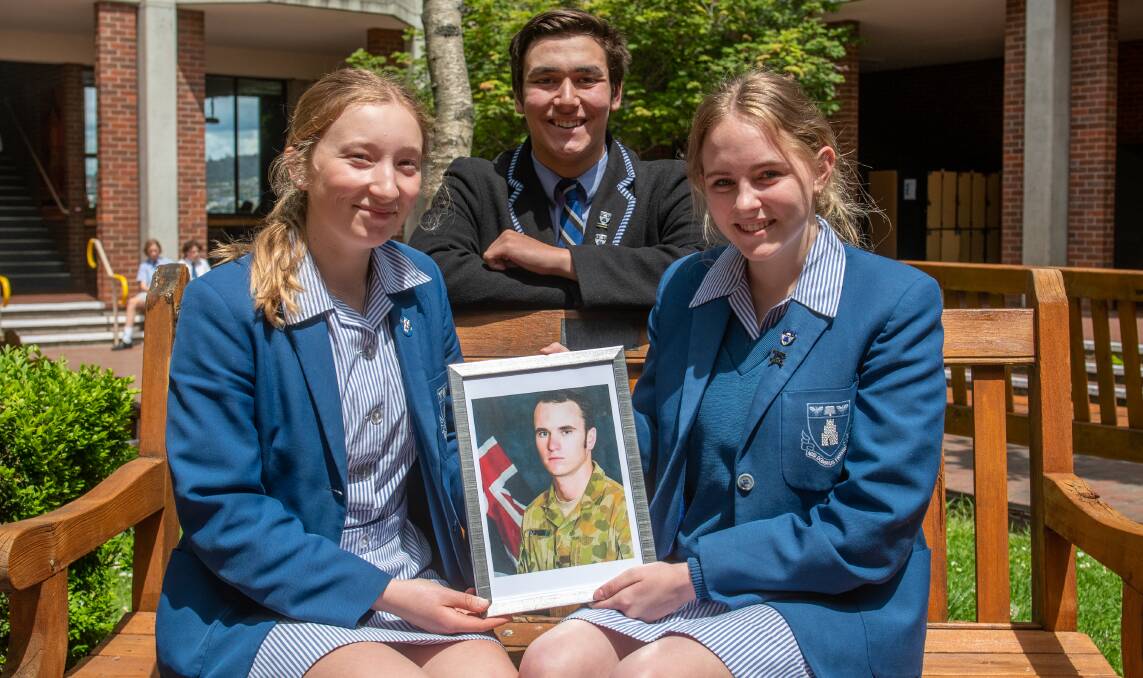 REMEMBERING: Lily Dunn, Skye Ellis and Thomas Beaumont with a photo of Corporal Richard Edward Atkinson. Picture: Paul Scambler