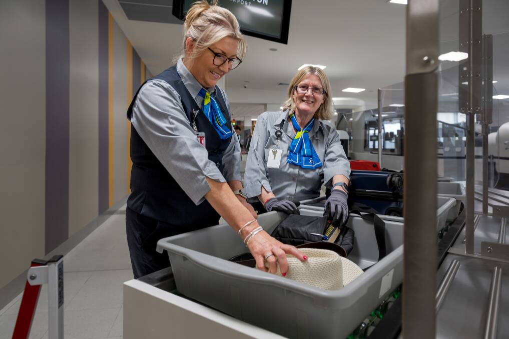Aviation Protection Officers Tania Clinton and Cheryl Shaw load luggage onto the conveyor. Picture by Phillip Biggs