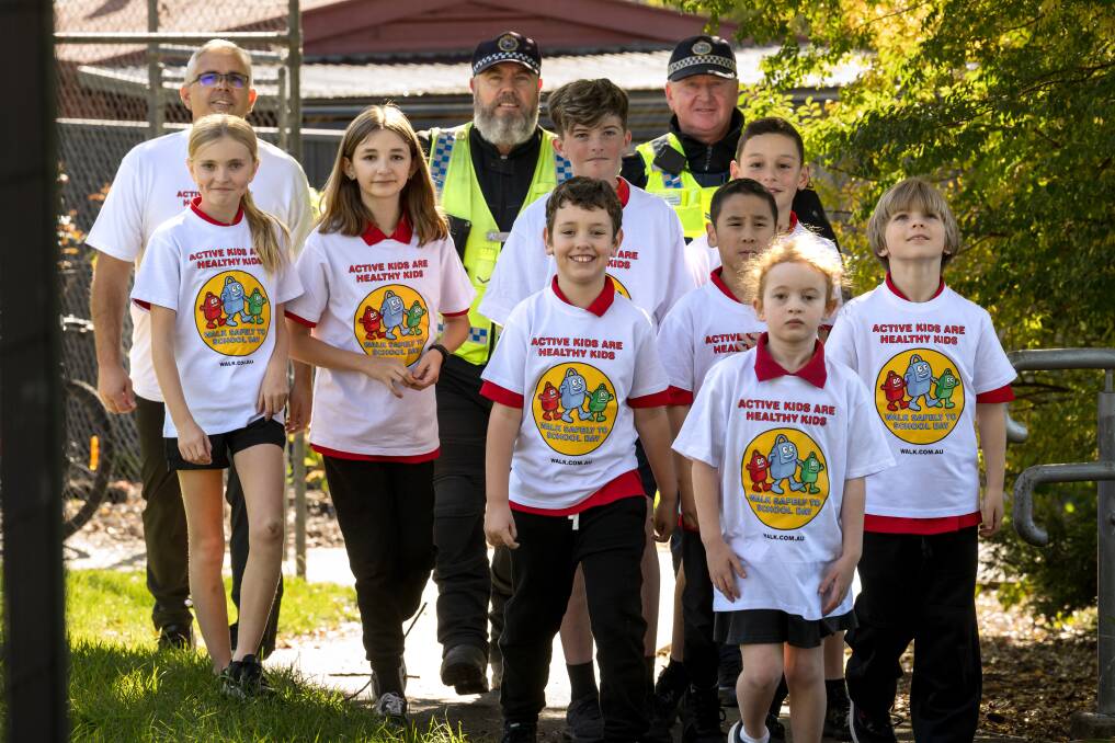 Summerdale Primary School students walk with Principal Adam Eastley and Tasmania Police First Class Constable Darren Chynoweth and Senior Constable Michael Grenda. Picture by Philip Biggs
