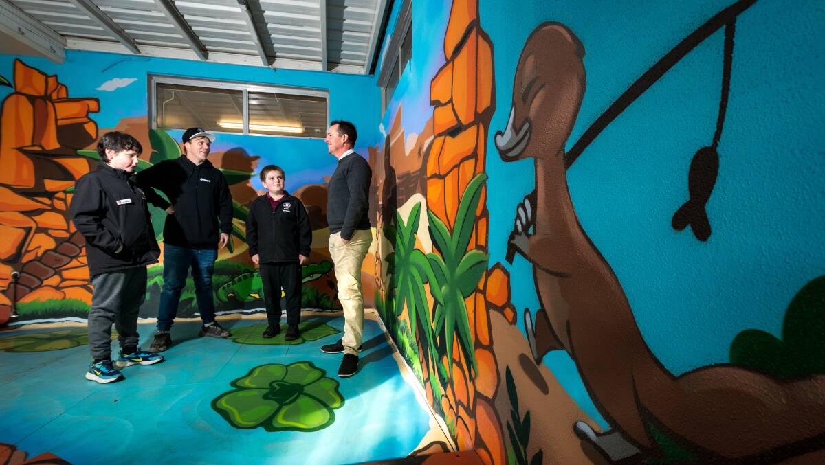 MURAL MAGIC: SRC vice president Darius Viney, artist James Cowan, SRC secretary Jordan Todd, and principal Jason Gunn with a mural at Ravenswood Primary. Picture: Phillip Biggs
