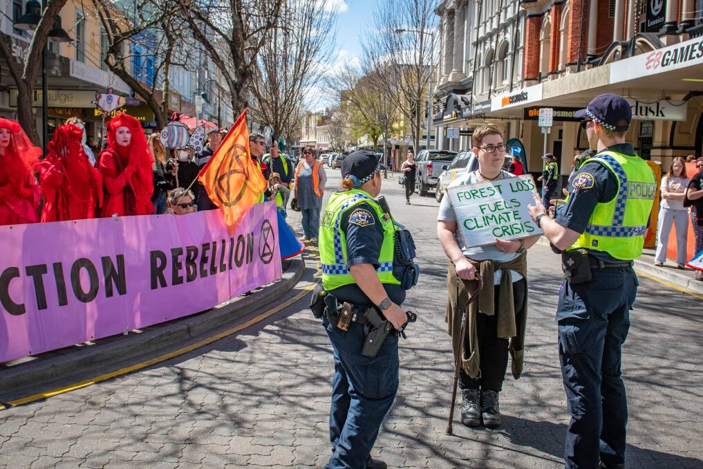 Police talk to Gabby Knox, before her arrest while Extinction Rebellion block the Avenue, in Brisbane Street, Launceston. Picture by Paul Scambler 