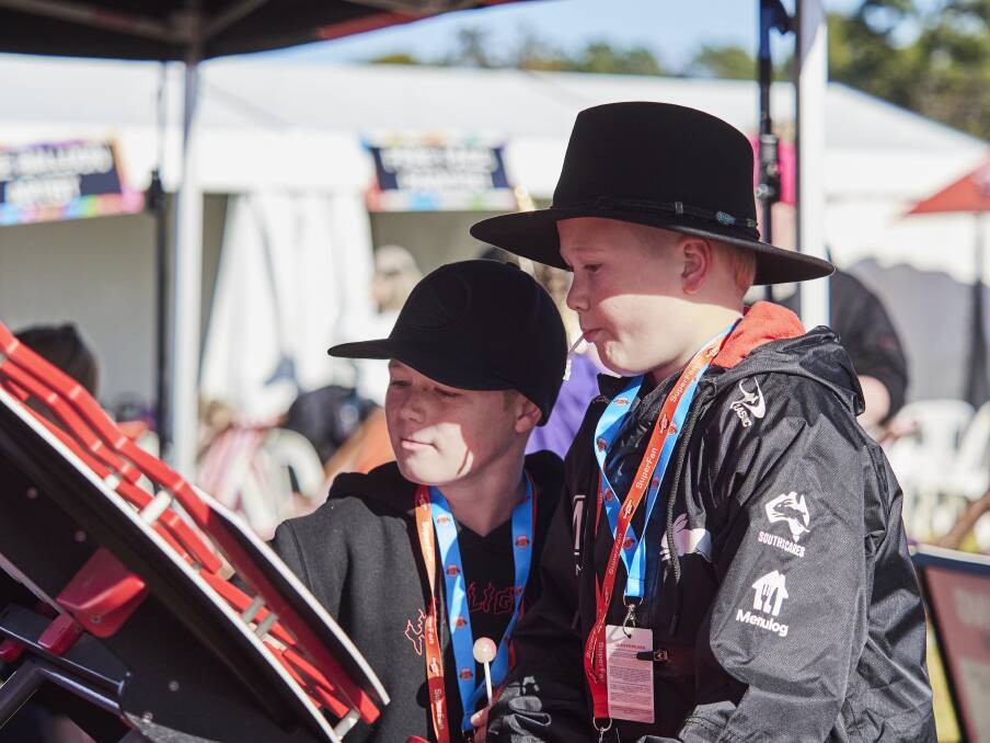 Dash Newell, 9, and Harly Newell, 11, of Newcastle, play one of the many interactive games in the Supercars SuperKids Zone.