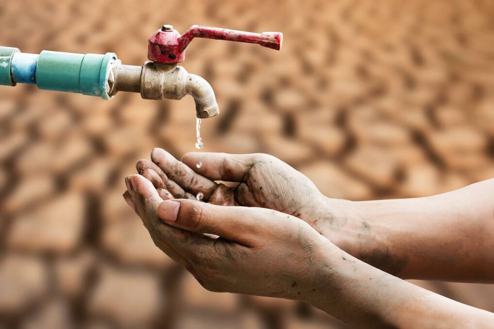 A hand under a tap against a parched ground. Picture from Shutterstock. 