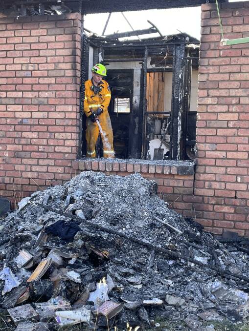 Fire crew extinguishes the last of the blaze at Westbury Road property. Picture by Paul Scambler 