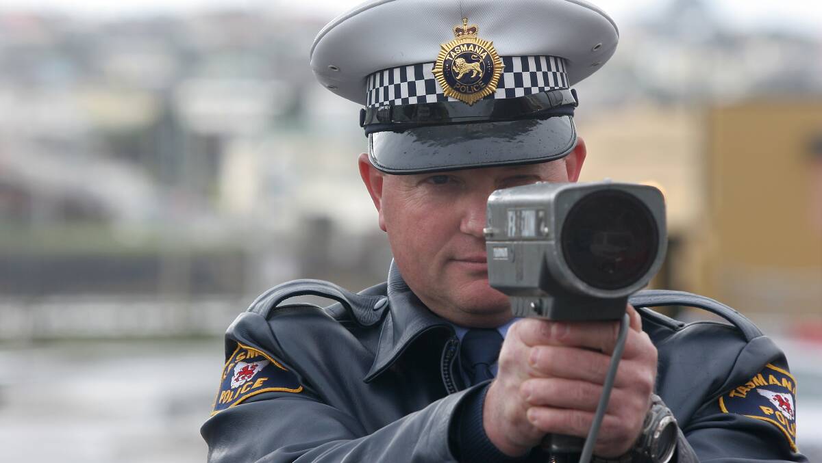 Officer Andrew Maingay with a speed gun on a Tasmanian road. Picture file