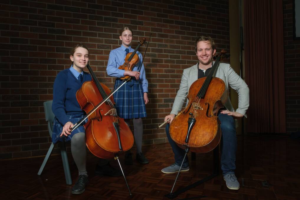Launceston Grammar students Davia, 14, and Heidi John, 13, and are being inspired by the Tasmanian Symphony Orchestra's principal cello, Jonathan Békés, to pursue their musical journeys . Picture by Craig George