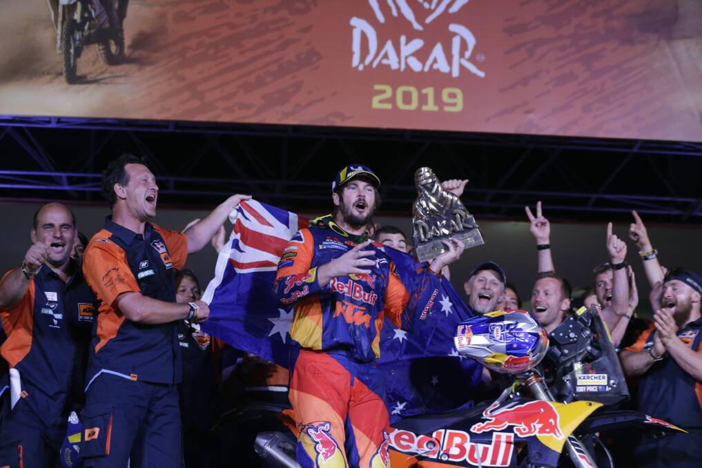 Toby Price celebrates with his team and the 2019 Dakar Rally winner's trophy in Lima. Picture: AP Photo/Martin Mejia