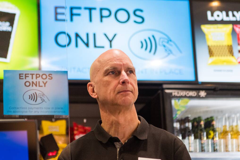 NO CASH THANKS: Phil Hall stands by the large signs which tell customers that Devonport's Reading Cinema will only take eftpos or credit cards for ticket payment. Picture: Phillip Biggs