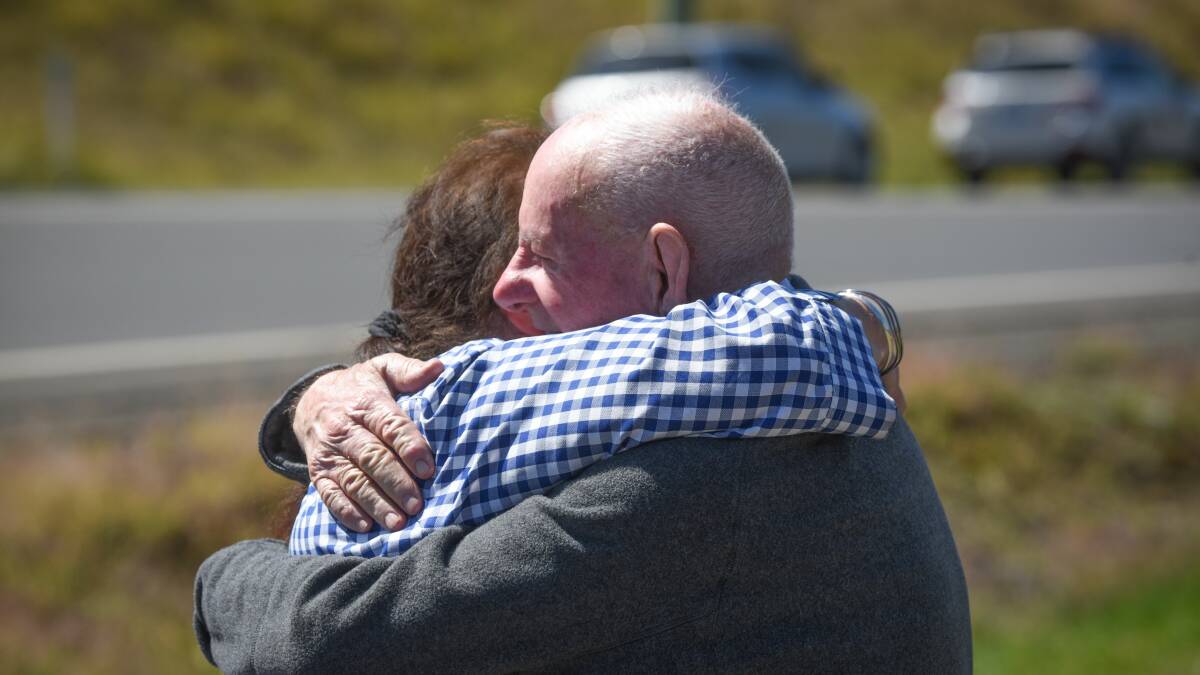 Ruth Nichols's neighbour Tom Moore gives her a hug after she arrived home to find her house engulfed in flames. Pictures: Paul Scambler