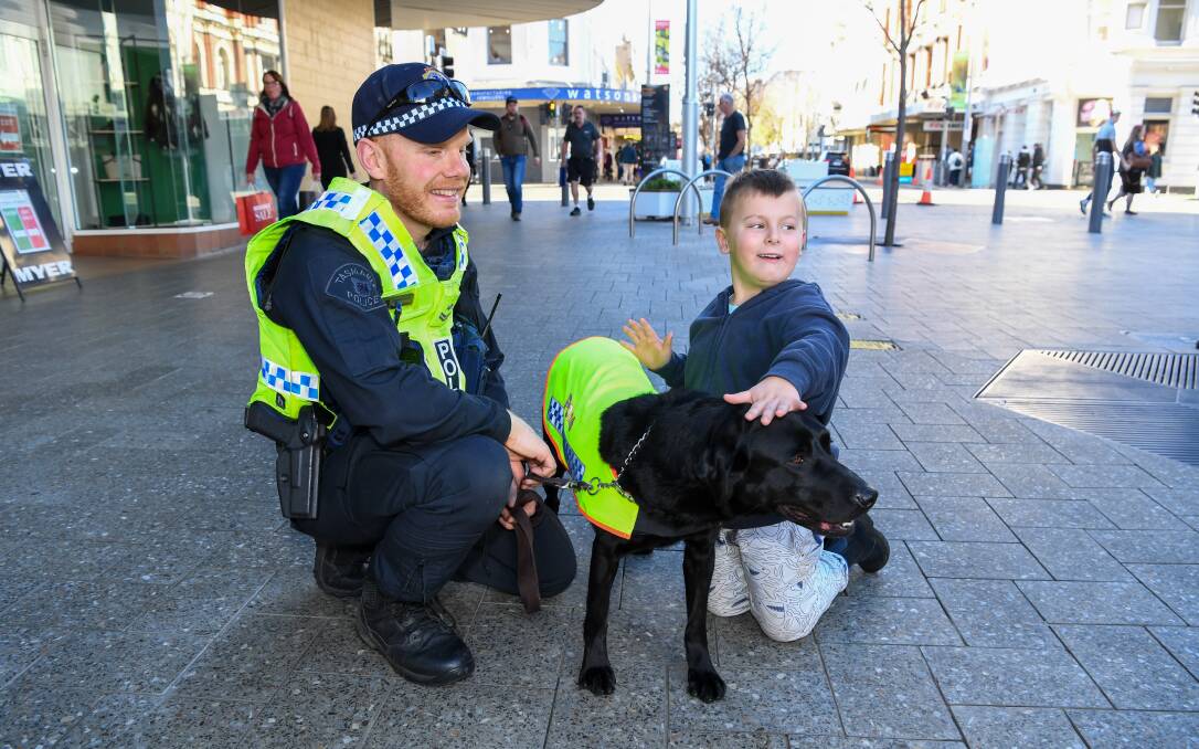 Senior Constable Josh Partridge and Police Dog Aggie stopping for a pat in the Brisbane Street Mall.