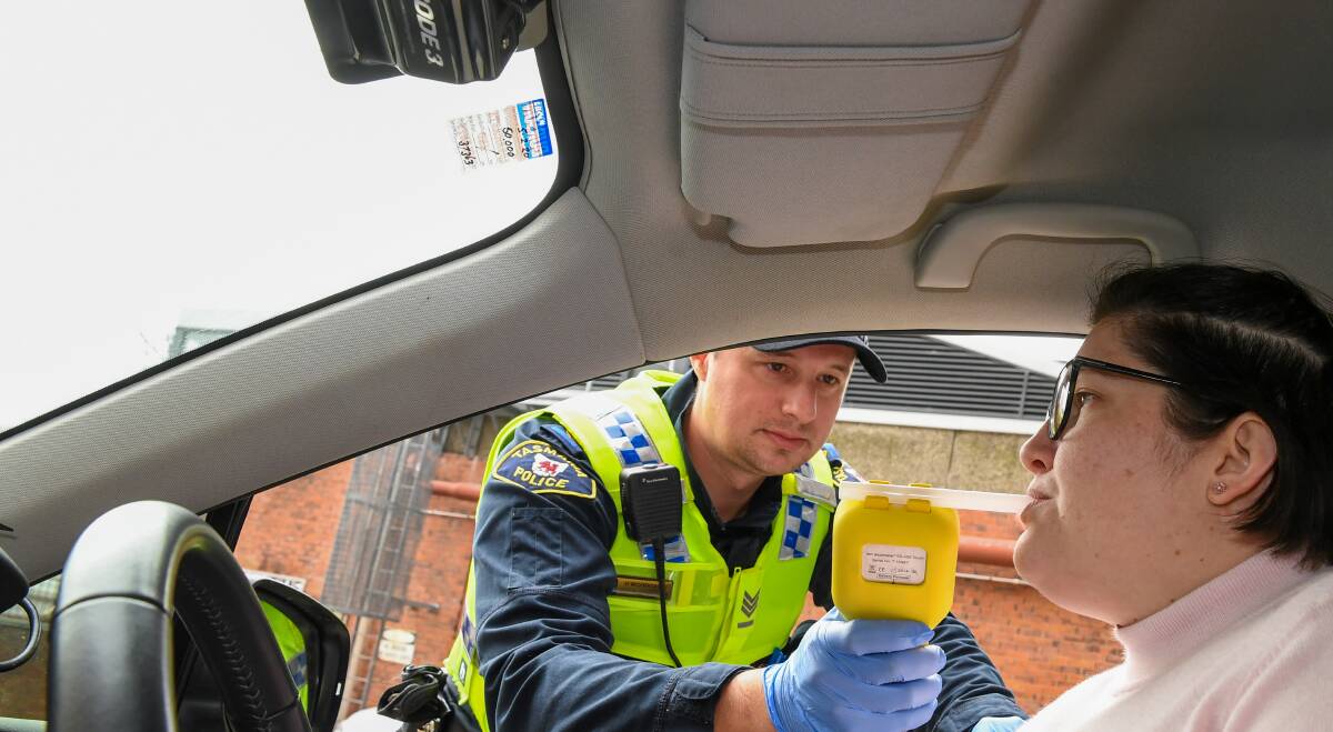 TESTING: Acting Sergeant Hamish Woodgate with a volunteer showing how officers conduct random breath tests. Picture: Neil Richardson