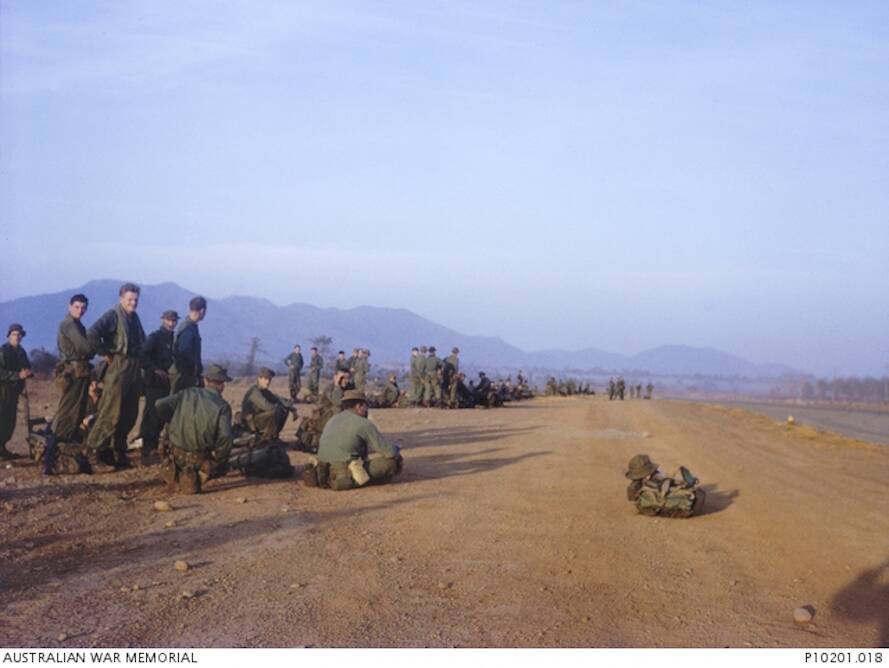 WAITING: Bob Millwood sitting far right with his back to the camera at Luscombe Field, Nui Dat. Picture: Australian War Memorial