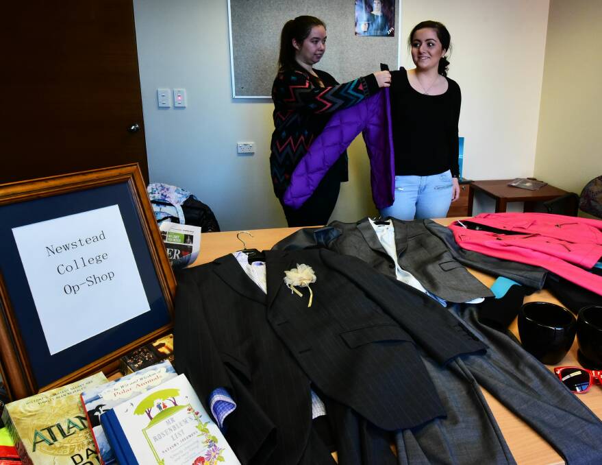 SHOPPING: Newstead College students Chloe Pickett and Meg McCullagh, both 18, set up for the school's op shop. Picture: Neil Richardson