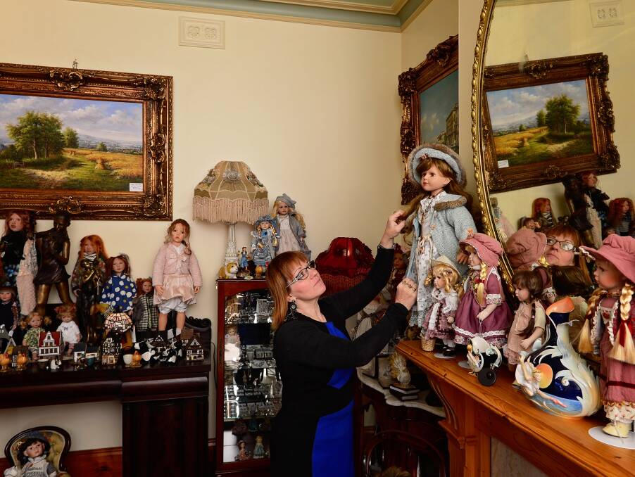 ECLECTIC: Reliquaire owner Sylvia Christie adjusts a doll on display at the new Hamilton Street location. 