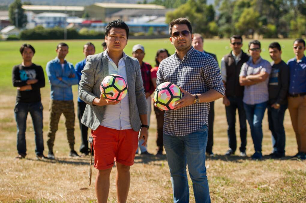 GAME ON: Bhutanese community member Kaman Monger and uni player Mohsen Hedayati with Bhutanese, Afghani and university team members. Picture: Scott Gelston. 