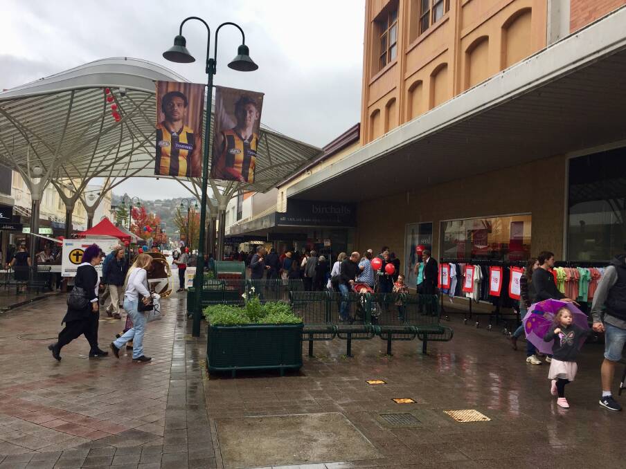 SHOP UNTIL YOU DROP: Shoppers in the mall duck out of the rain to check out the Crazy Day sale racks at Myer. Picture: Kasey Wilkins