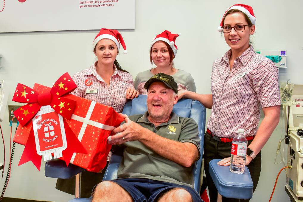 GIFT: Red Cross Launceston Donor Centre's Tammy Mackenzie, Sophie Lethborg and Jenna Sommerville with donor Michael Flemingham, who made a milestone 100th donation on December 12. Picture: Neil Richardson