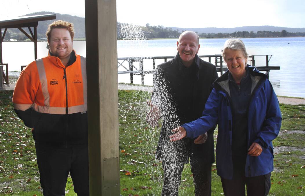 TEAM UP: TasWater's Sam Child, Break O'Day mayor Mick Tucker, and Happy Fish's Natalie Walter with the outdoor shower. Picture: supplied