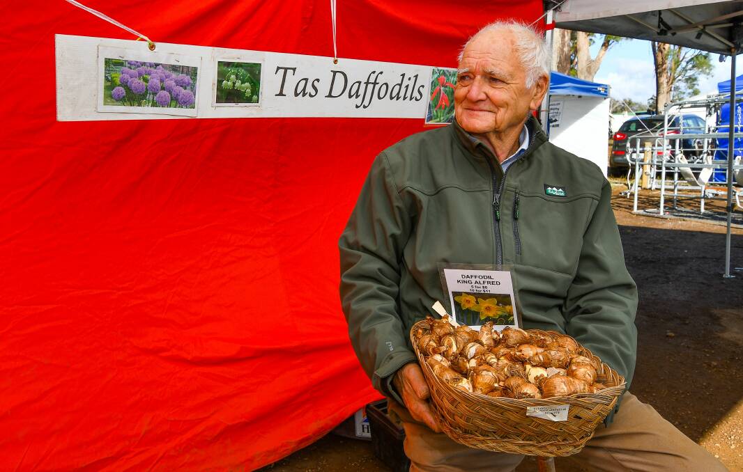 DAFFODILS AND MORE: Bill Waldron holds a basket of King Alfred daffodil bulbs at his stall at Agfest, where he has been selling bulbs for more about 30 years. Mr Waldron grows most of the bulbs they sell himself. Picture: Scott Gelston