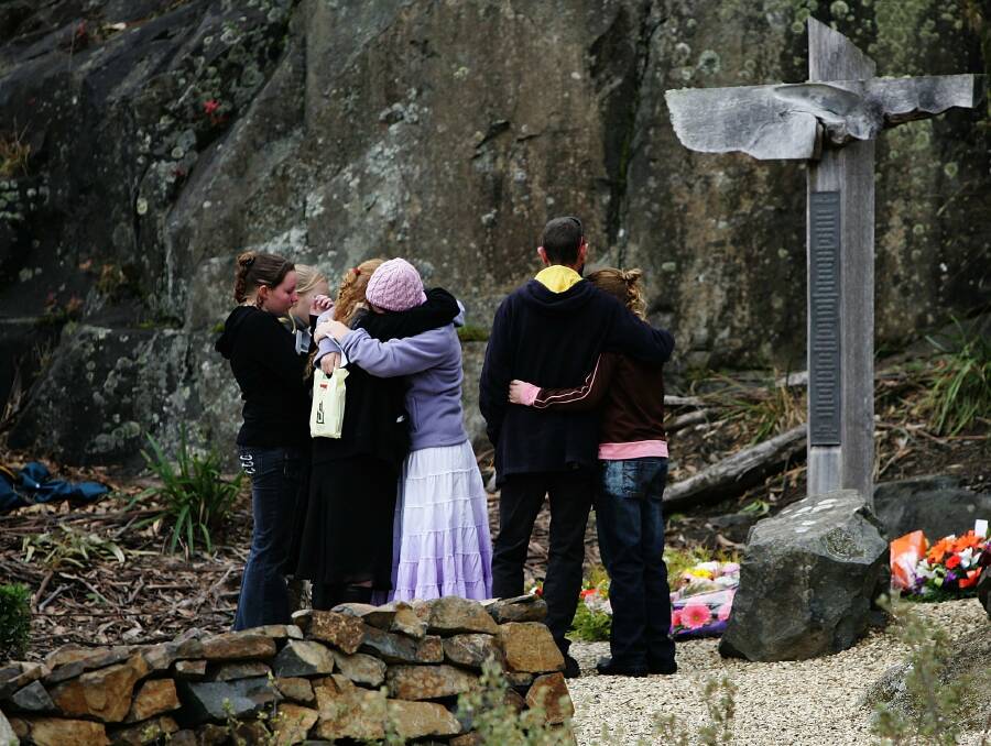 MOURNING: A family embraces at the Port Arthur memorial site during a commemoration service to mark the 10th anniversary of the massacre. Picture: Getty Images.