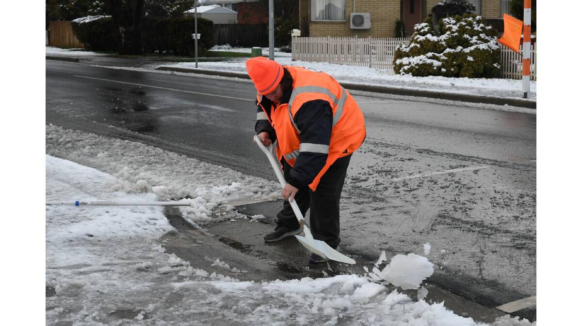 School crossing officer Katrina Mallett shovels snow to make it safe for children at Ravenswood Primary School