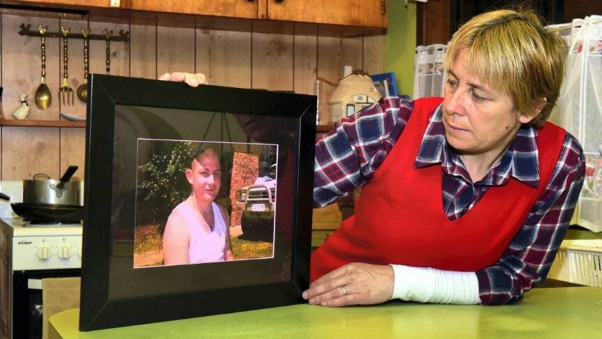 MISSING: Lillian Watkins holds a framed photo of her missing son Christopher, who police fear was murdered in 2013.