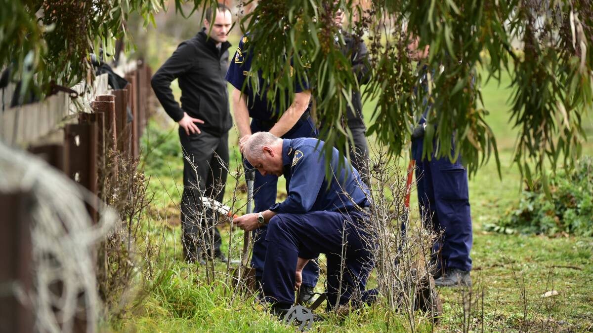 Police scour the site of Shane Barker's 2009 murder at Campbell Town in August last year.
