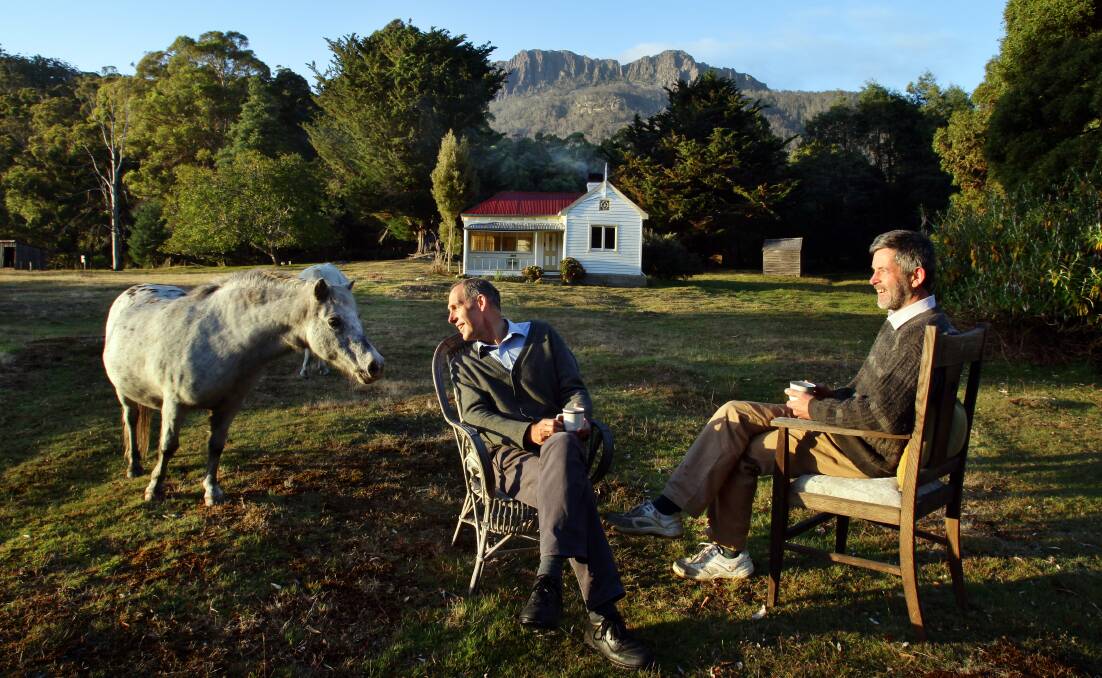 AT HOME: A photo of Bob Brown and Paul Thomas with their trusty lawnmower at their cottage in Liffey Valley in 2012, which is now owned by Bush Heritage.