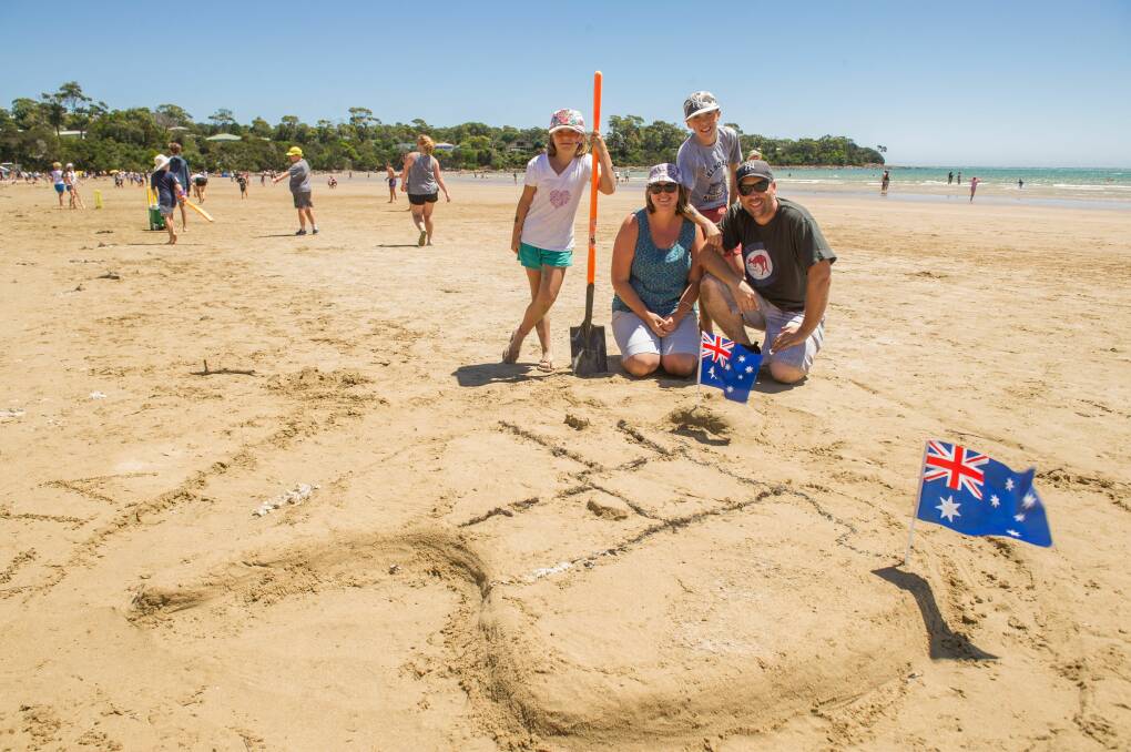 LONG WAY FROM HOME: Perth Family Clarissa, 9, Michelle, Zachary, 11, and Adrian Ward with their map of Australia at Greens Beach on Australia Day. Picture: Scott Gelston