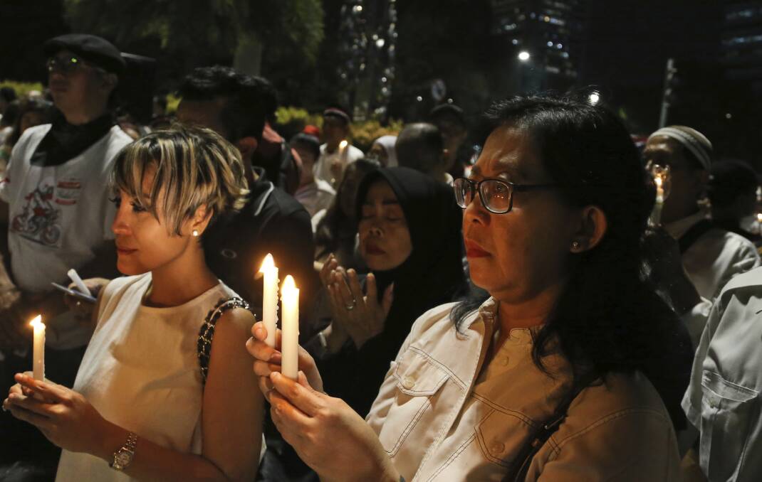PRAYERS: Indonesians pray during a candlelight vigil for the victims of the attacks in Surabaya. Picture: AP