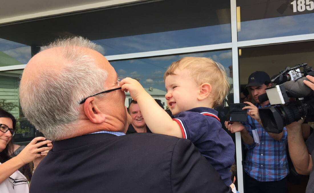 Prime Minister Scott Morrison holds a toddler during his visit to Launceston. Picture: Matt Dennien