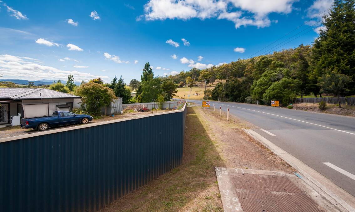 The fencing that residents say limits visibility looking south from the Gravelly Beach Road intersection. Picture: Phillip Biggs