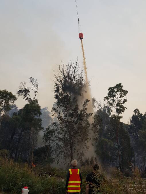 Water is dumped on smouldering trees as part of the fire effort. Picture: Ashley Stewart