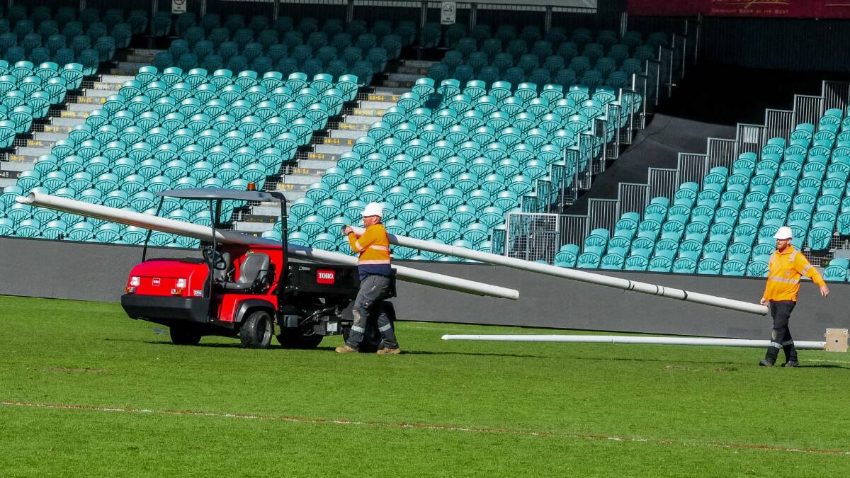 Workers remove the goal posts at UTAS Stadium in preparation for the resurfacing works. Picture: Neil Richardson