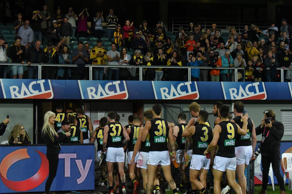 Richmond make their way off UTAS Stadium after an eight-point win over Hawthorn on Saturday night. Picture: Paul Scambler