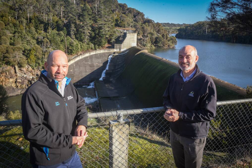 Hydro Tasmania aquatic scientist David Ikedife and Energy Minister Guy Barnett with the eel bypass flowing behind them. The bypass will only operate from December to April. Picture: Paul Scambler