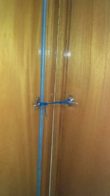 The mother has used wire to tie together doors to prevent access to the mould-infested room. Picture: supplied by resident