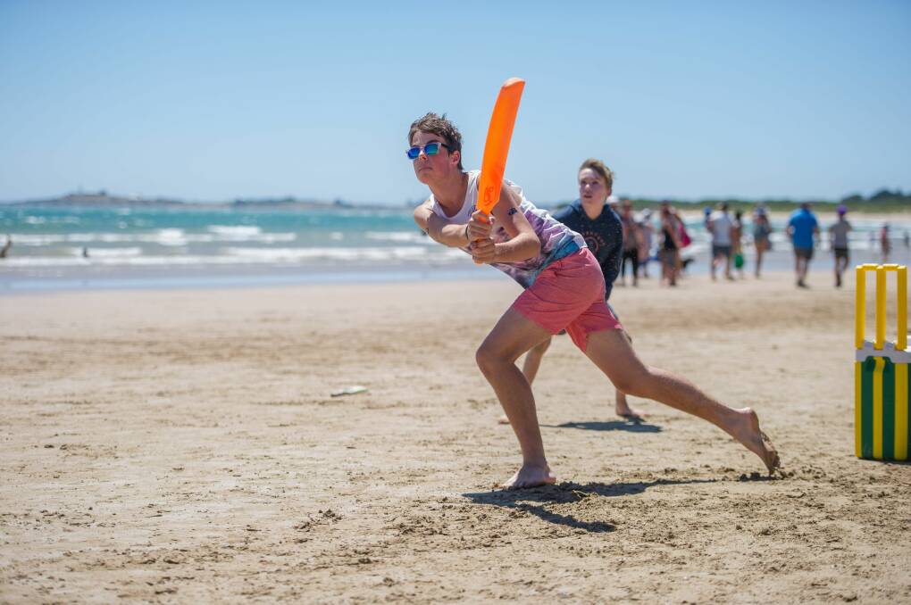 Lachlan Harris, 16, knocks one away as Ash Carr, 11 , mans the slips during beach cricket at Greens Beach. Pictures: FILE