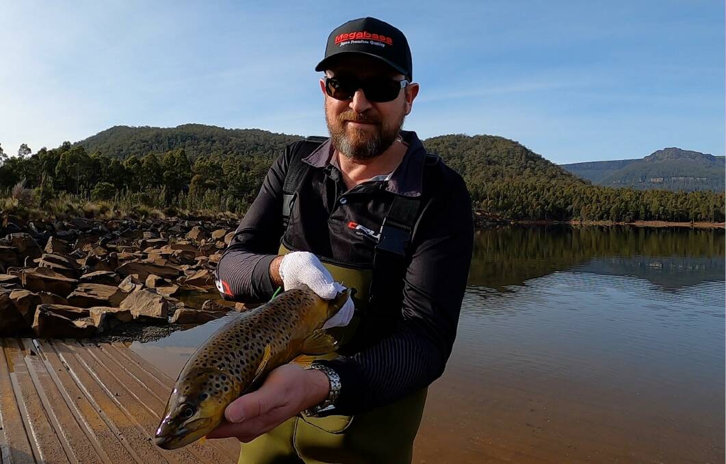 Hook, line and sinker: Sherriff Agencies sales director Matt Sherriff with one of five brown trout released in Huntsman Lake. Picture: supplied