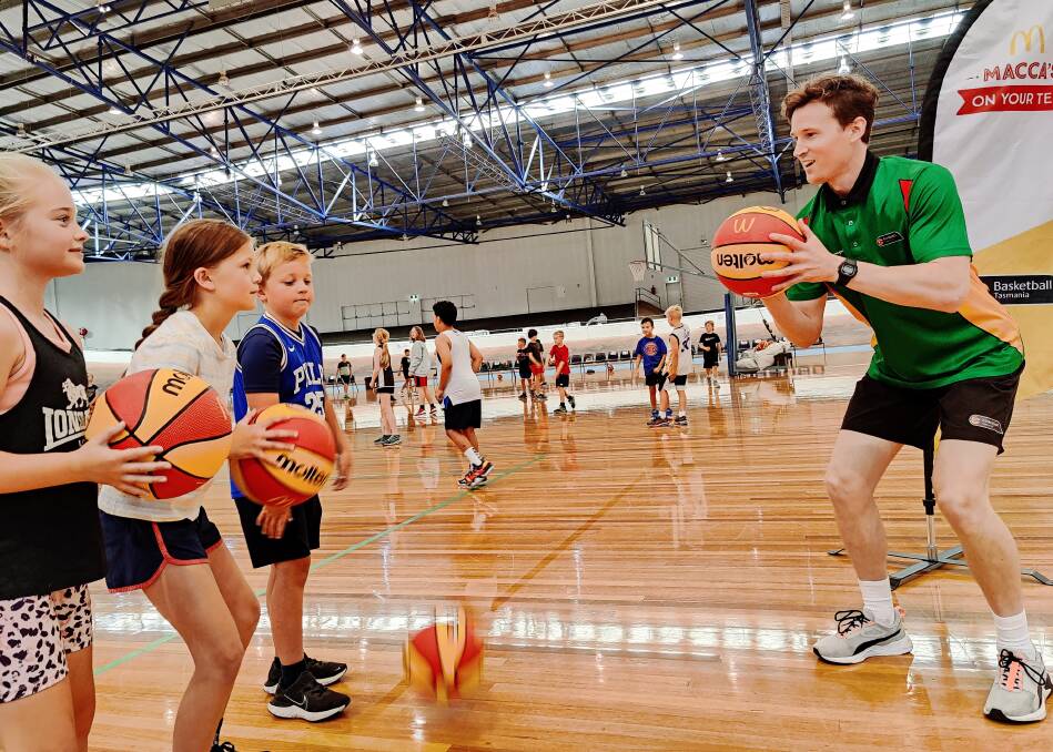 Watch and learn: Nine-year-old Annabelle Peck, Ella Powell, 9 and Thomas Seen, 7 as well as Basketball Tasmania's Nathan Brereton. Picture: Harry Murtough 