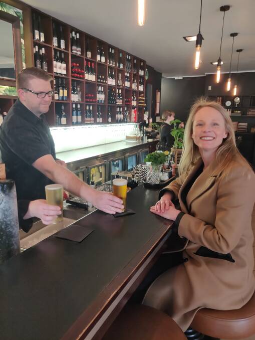 Order up: Metz co-owner David Lewis serves Small Business Minister Sarah Courtney a beer at the bar. Picture: Harry Murtough 