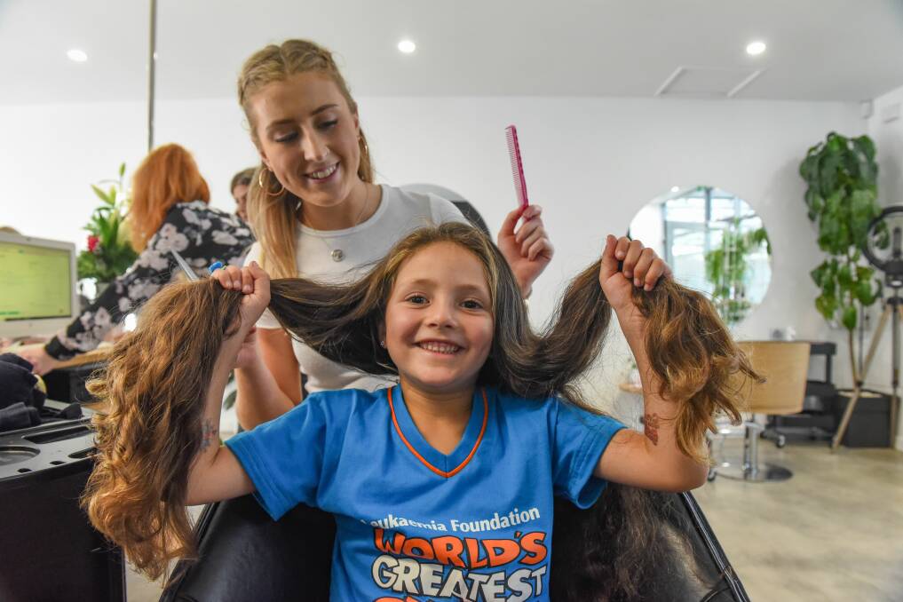 Quite the trim: Maeve Murfett, 5, has raised more than $4000 for the Leukemia Foundation. Gracie Wright of Pump House Hair cuts Maeve's hair which will be used to make wigs. Picture: Paul Scambler