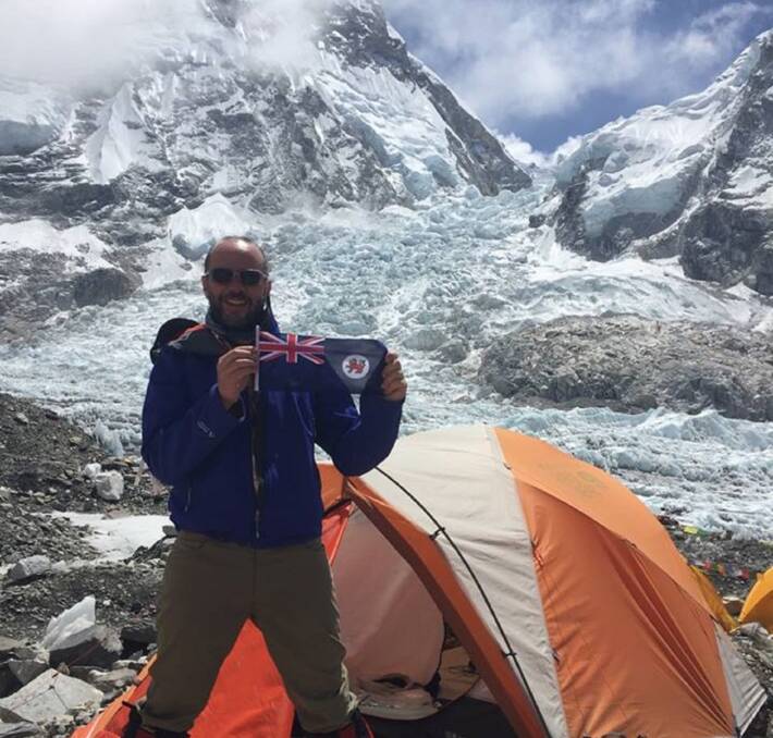 Super summit: Tasmanian mountaineer John Zeckendorf making his way up Mount Everest with a little piece of home. Picture: supplied