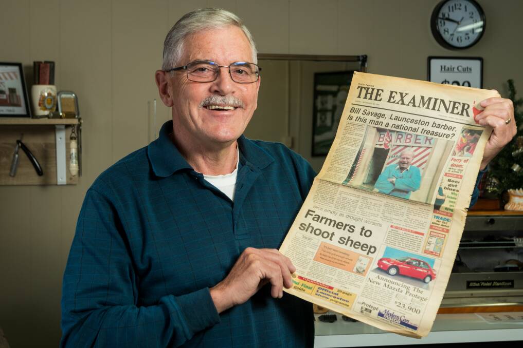 Peter Savage holding a 1994 copy of The Examiner Newspaper, featuring his father Bill Savage on the front.