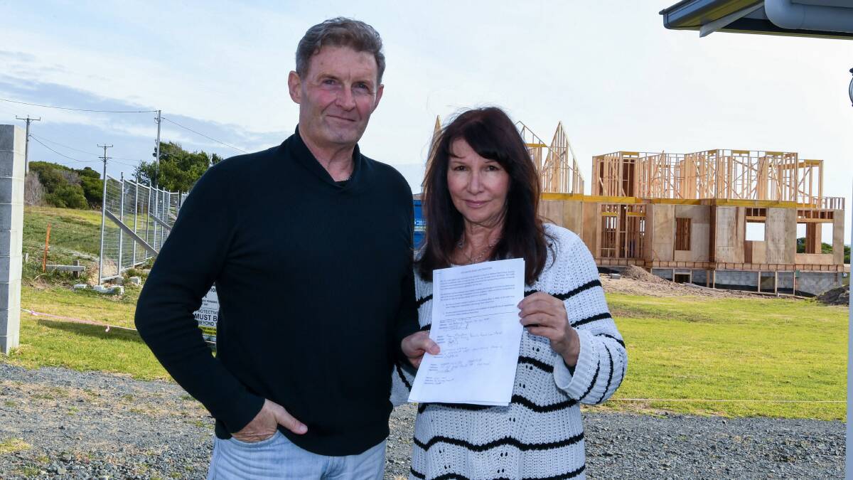 Frustrated: Phillip and Susan Hawksley, of Bellbuoy Beach, with a petition calling on a reduced speed measure at the small community. Picture: Neil Richardson