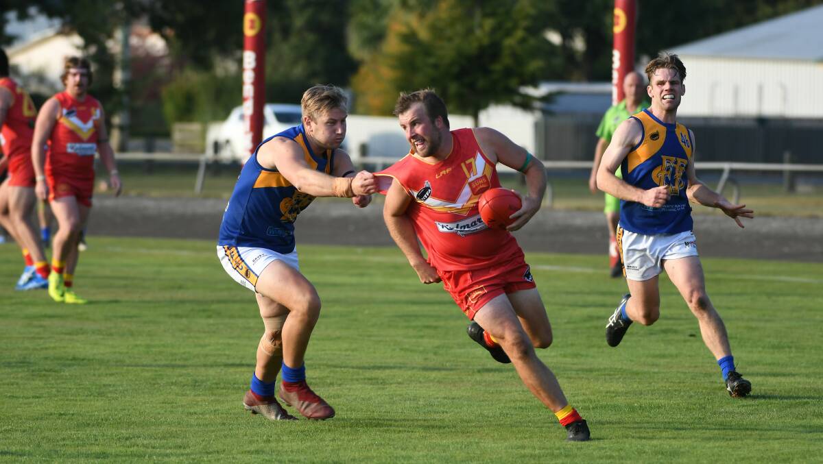 VICTORY: Meander Valley's Brodie Langley dodges Evandale's Geoff Stick in the Suns' first win over the Eagles. Picture: Paul Scambler